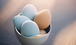 a bowl with an egg next to it and a blue one