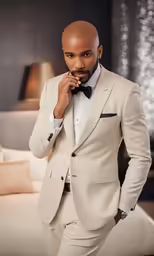 a man in a tan suit posing for a picture
