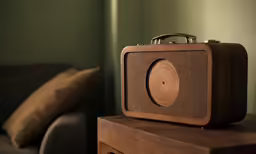 a brown wooden radio sits on top of a table next to a couch