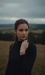 a young girl poses with braid in a field