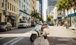 motor scooter is parked on the street near cars