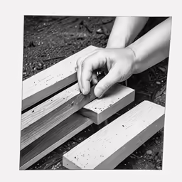 hands are holding onto wooden pieces on a bench