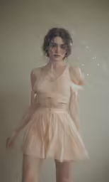 the woman is wearing a pink dress while she is in motion