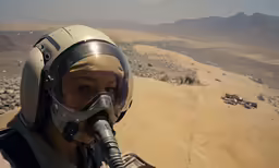 a person wearing a helmet and goggles standing in the desert