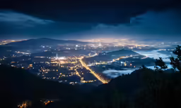 a city lights are shown under dark cloudy skies
