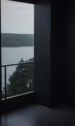 a room with an open window looking out at the water