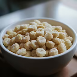 a white bowl of bananas on a wooden table