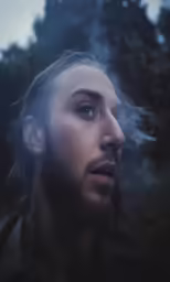 a close up shot of a man with a smoke coming out
