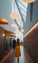 woman walking down the hall with light fixture and windows above