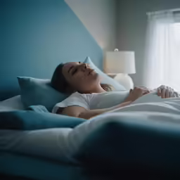 a woman sleeping in bed in front of a window
