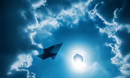 an airplane is flying high in the blue sky