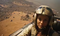 a woman in an old helicopter flying near some rocks