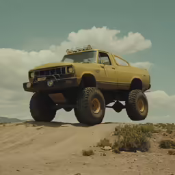 a big truck riding over a dirt field