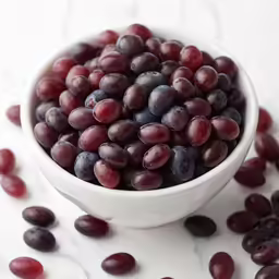 red and black grapes in a white bowl