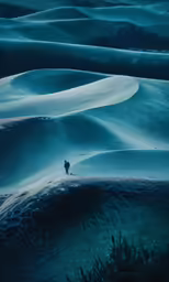 a lone man walking across an overcast mountain