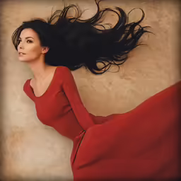 the woman is laying down wearing a long red dress