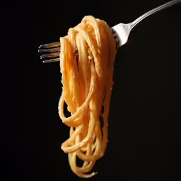 the fork is holding the noodles that were cooked on the stove