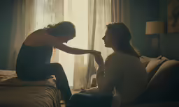 two woman who are sitting on a couch