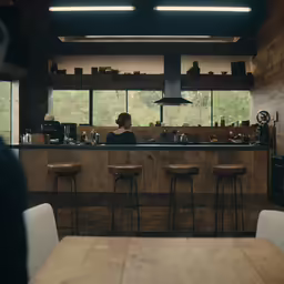 a person behind a bar in front of a window