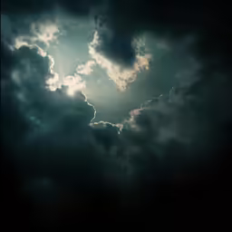 the sun peeks through the dark clouds