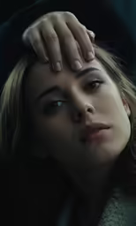 a young woman holding her hand to her face