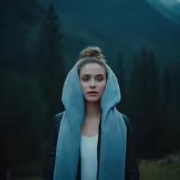 a woman with a towel over her head standing outdoors
