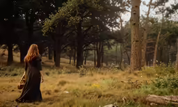 a beautiful woman with red hair walking through a forest