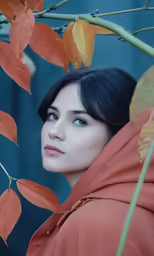 a woman in an orange dress is next to a tree with leaves