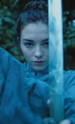 a young woman standing with a sword behind her