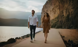 man and woman walking by the water holding hands