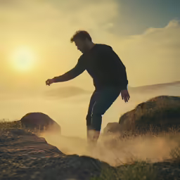 the man is riding his skateboard on the rocky hill