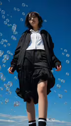 a woman in black and white is walking among bubbles,a young woman in black and white is standing among bubbles
