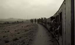 a train traveling through the desert under a cloudy sky