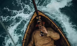 a man in a brown jacket in a canoe using his phone