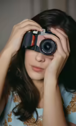 young woman taking picture with camera close to her eyes