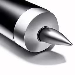 a silver pen sitting in the shape of a bullet