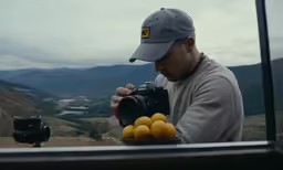 man with hat and camera preparing to photograph lemons