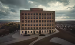 a building with three floors and many windows is standing alone in an urban area