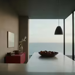 a bowl of fruit on the kitchen counter by the water