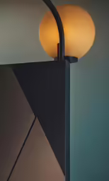 two light fixtures on a pole against a wall