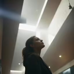 a woman with her eyes closed staring up
