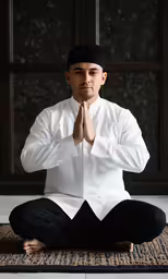 a man sitting in a lotus position on a rug
