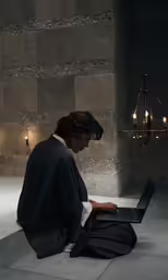 woman on laptop at stylish with hanging light in dark room