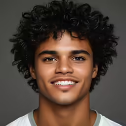 a man with curly hair smiling for the camera