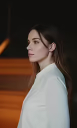 a woman with dark hair, wearing white, posing