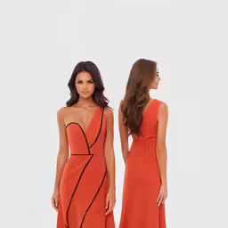 a woman standing next to a woman in an orange gown