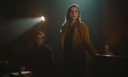 the actors are standing in a dark room
