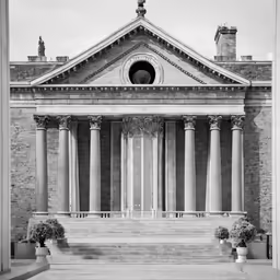 an old building with two vases and one window on the front