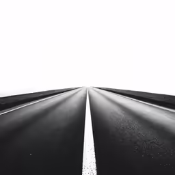 a black and white photo of the highway leading to another direction