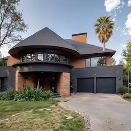 a large house sitting on the side of a lush green hillside